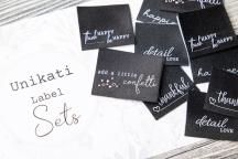 Designerset med vävda etiketter 'happiness black and white' från Unikati - Artikelnummer 9118