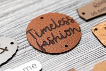 Rund etikett i äppelläder med graveringen 'Timeless fashion' - Artikelnummer 3003