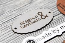 Ljust konstlädermärke med texten 'designed & handmade' - Artikelnummer 3003