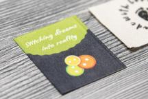 Satinera-etikett med knappmotiv och texten 'Stitching dreams into reality' - Artikelnummer 3007